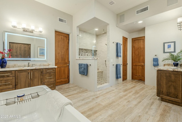 bathroom featuring a shower with door, vanity, and hardwood / wood-style floors