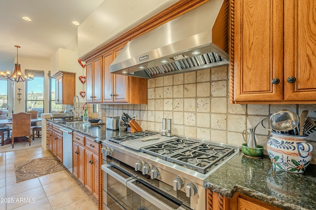 kitchen featuring double oven range, ventilation hood, decorative backsplash, and dark stone countertops