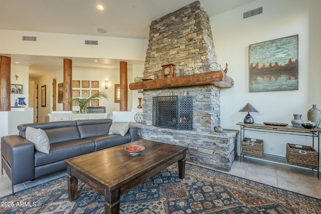 living room with ornate columns, a fireplace, and light tile patterned floors