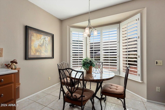 tiled dining room featuring a chandelier