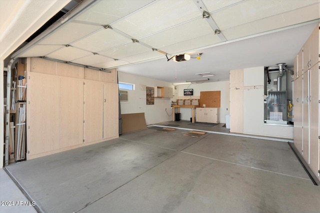 garage featuring a garage door opener and heating unit