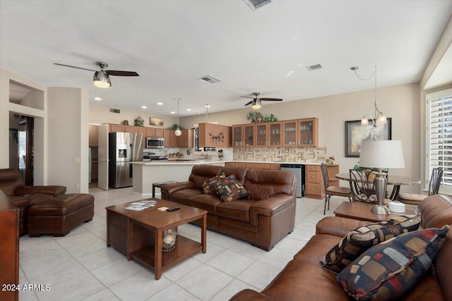 tiled living room featuring ceiling fan with notable chandelier