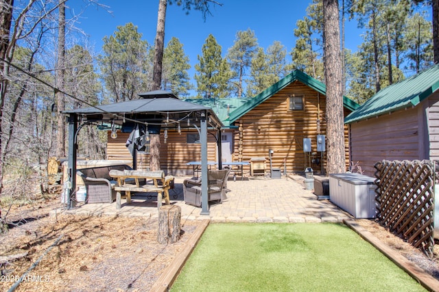 669 W Monarch Cir, Lakeside, AZ 85929 - back of property featuring outdoor lounge area, log siding, a patio area, metal roof, and a gazebo