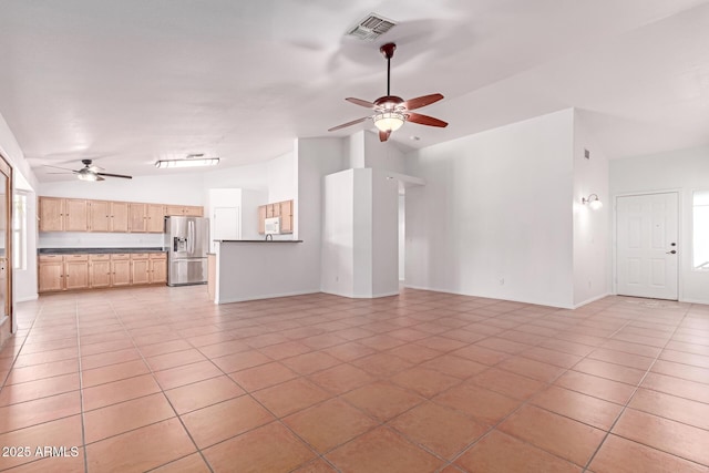 unfurnished living room featuring visible vents, ceiling fan, light tile patterned flooring, and vaulted ceiling