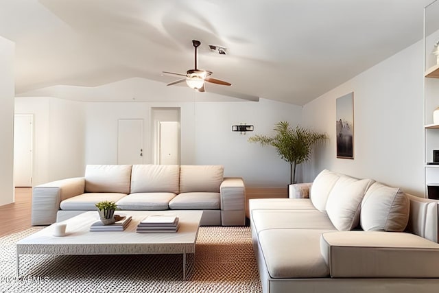 living area featuring vaulted ceiling, wood finished floors, and a ceiling fan