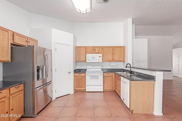 kitchen featuring dark countertops, a peninsula, white appliances, high vaulted ceiling, and a sink