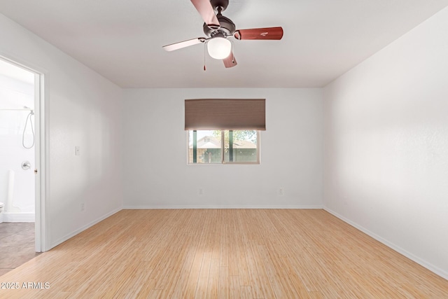 unfurnished room with baseboards, wood finished floors, and a ceiling fan