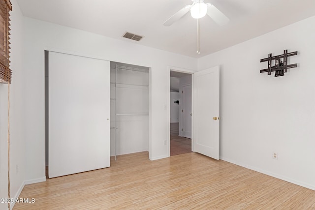 unfurnished bedroom with a closet, baseboards, visible vents, and light wood-style flooring