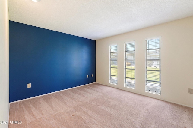 carpeted empty room with a textured ceiling