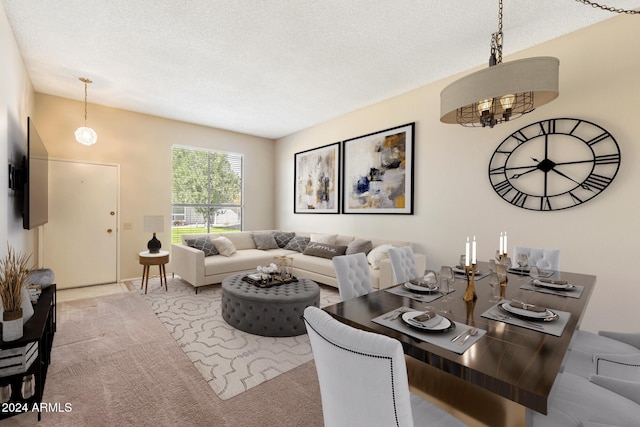 dining area featuring light carpet, a textured ceiling, and a notable chandelier