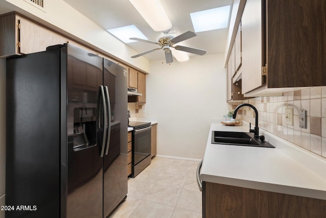 kitchen with backsplash, stainless steel refrigerator with ice dispenser, black range with electric cooktop, and a skylight