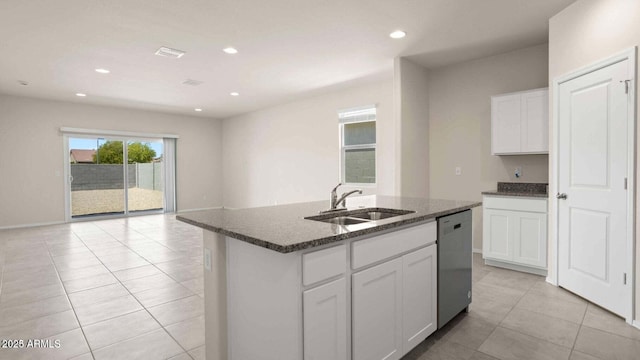 kitchen with a kitchen island with sink, sink, stainless steel dishwasher, dark stone countertops, and white cabinetry