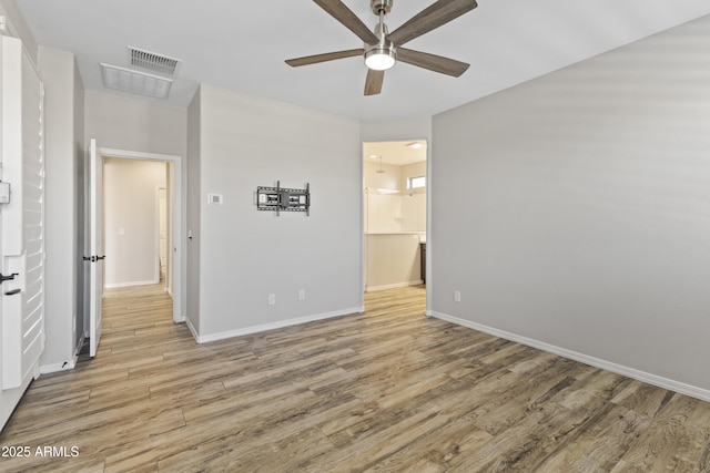 spare room with ceiling fan and light wood-type flooring