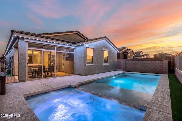 pool at dusk with a patio