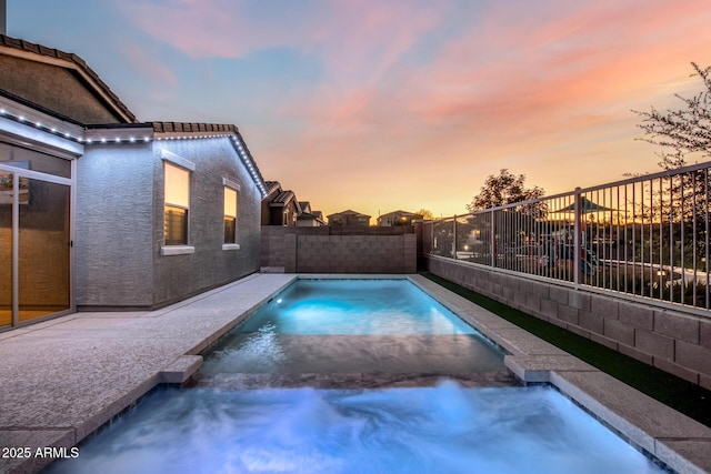 view of pool at dusk