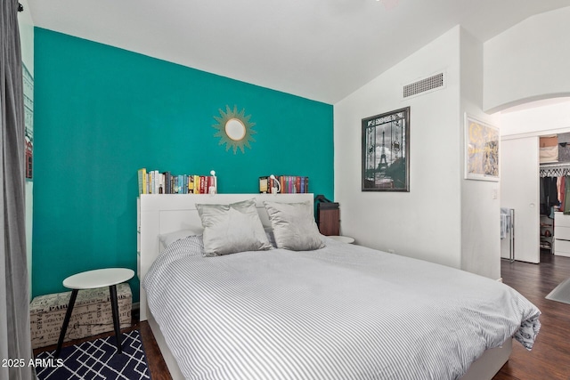 3222 E Cortez St, Phoenix, AZ 85028 - bedroom featuring an accent wall, vaulted ceiling, arched walkways, wood finished floors, and a closet