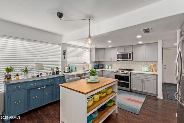 3222 E Cortez St, Phoenix, AZ 85028 - kitchen featuring appliances with stainless steel finishes, wood counters, a sink, dark wood-type flooring, and decorative light fixtures