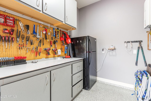 4876 N 207th Ln, Buckeye, AZ 85396 - kitchen with freestanding refrigerator, light countertops, white cabinetry, and baseboards