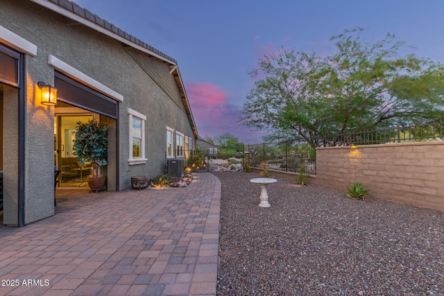 4876 N 207th Ln, Buckeye, AZ 85396 - yard at dusk featuring a patio area, cooling unit, and fence