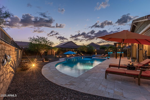 4876 N 207th Ln, Buckeye, AZ 85396 - pool at dusk with a patio, an outdoor pool, and a fenced backyard