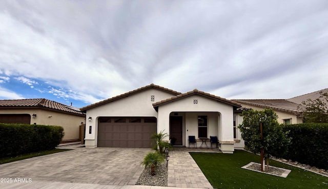 6947 W Spur Dr, Peoria, AZ 85383 - mediterranean / spanish-style home featuring stucco siding, an attached garage, decorative driveway, a front yard, and a tile roof