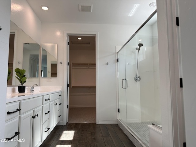 6947 W Spur Dr, Peoria, AZ 85383 - full bathroom featuring a stall shower, vanity, wood finished floors, a spacious closet, and recessed lighting