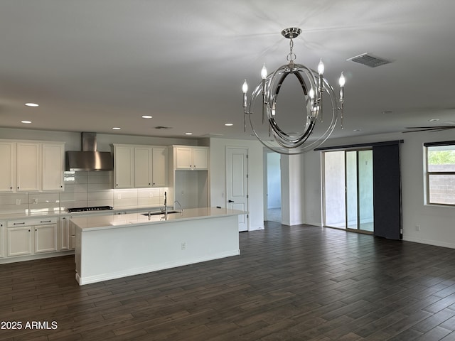 6947 W Spur Dr, Peoria, AZ 85383 - kitchen with wall chimney range hood, open floor plan, a chandelier, a kitchen island with sink, and recessed lighting