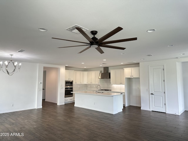 6947 W Spur Dr, Peoria, AZ 85383 - kitchen featuring wall chimney exhaust hood, a ceiling fan, a chandelier, dark wood-style floors, and recessed lighting