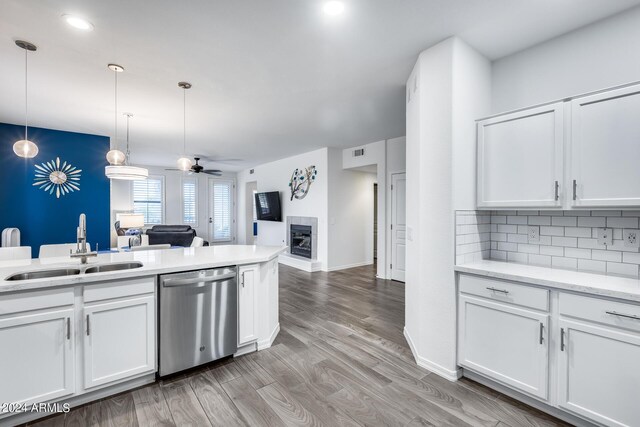 kitchen with ceiling fan, hanging light fixtures, white cabinetry, and stainless steel dishwasher