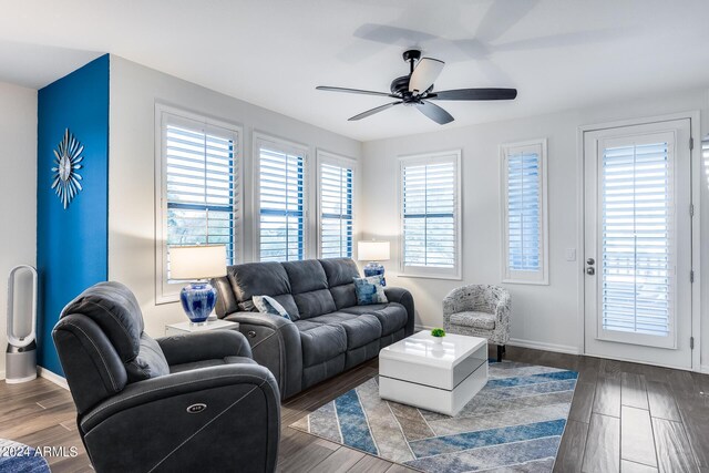 living room with ceiling fan and dark hardwood / wood-style flooring