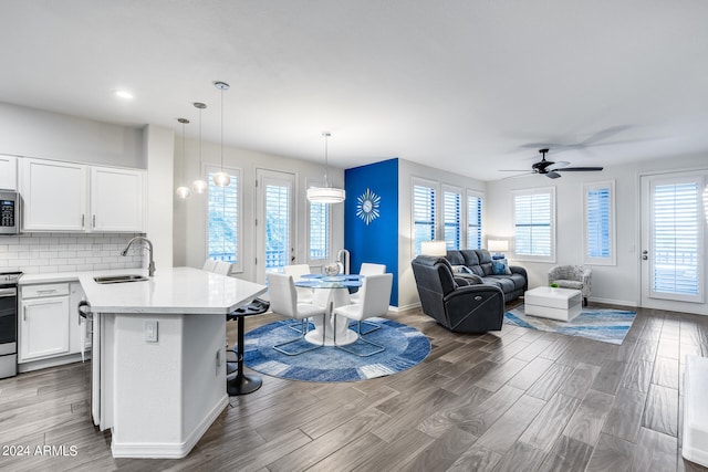 kitchen featuring a healthy amount of sunlight, a breakfast bar area, sink, and white cabinetry