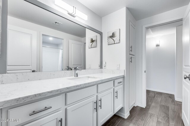 bathroom with curtained shower, hardwood / wood-style flooring, and vanity