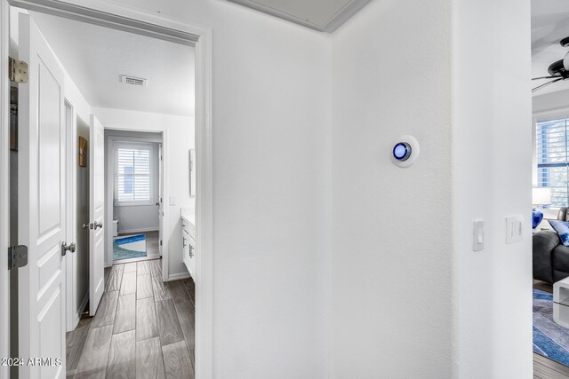 hallway with a healthy amount of sunlight and light hardwood / wood-style floors