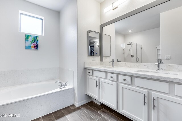 bathroom featuring vanity, wood-type flooring, and plus walk in shower