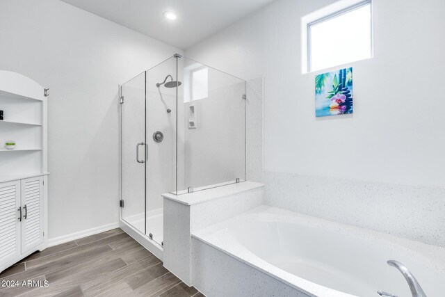 bathroom with hardwood / wood-style flooring and plus walk in shower