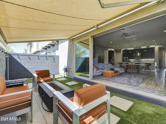 view of patio / terrace with an outdoor living space with a fire pit and ceiling fan