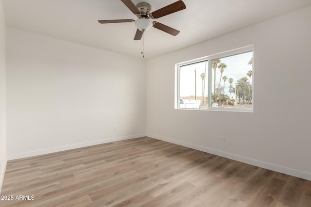 empty room featuring light wood-style floors, baseboards, and a ceiling fan