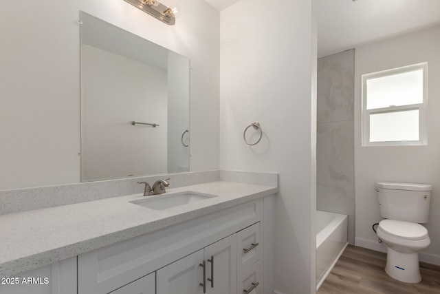 full bathroom featuring toilet, wood finished floors, vanity, and baseboards