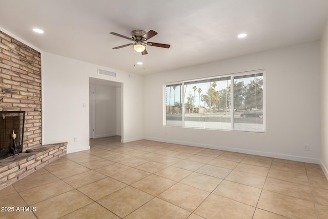 unfurnished living room featuring light tile patterned floors, visible vents, a ceiling fan, a brick fireplace, and baseboards