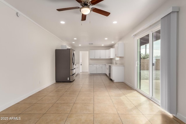 kitchen with stainless steel appliances, light countertops, white cabinets, light tile patterned flooring, and a sink