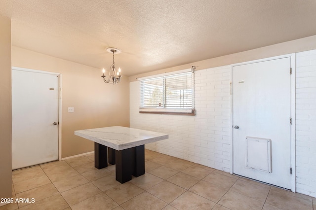 4565 Aspen Dr, Sierra Vista, AZ 85635 - tiled dining area featuring a notable chandelier, brick wall, and a textured ceiling