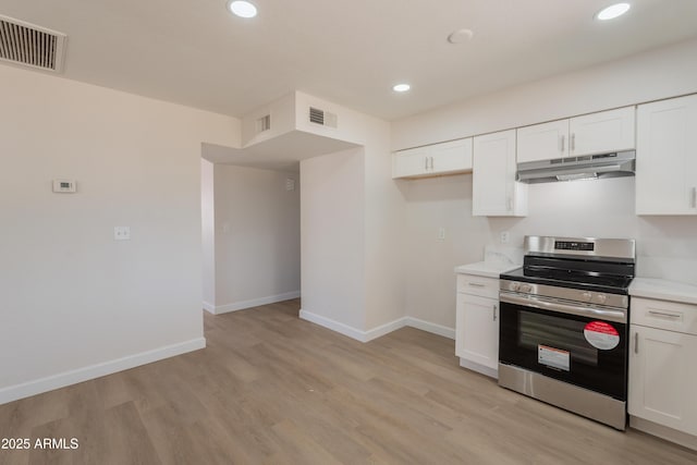 1310 E Ironwood Dr, Buckeye, AZ 85326 - kitchen featuring stainless steel range with electric stovetop, under cabinet range hood, light wood-type flooring, recessed lighting, and white cabinetry