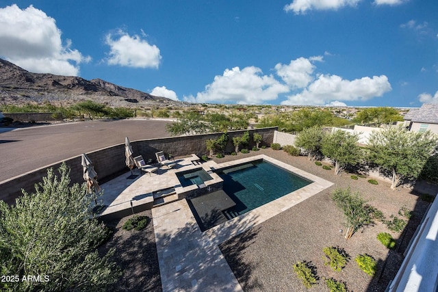 21194 W Hillcrest Blvd, Buckeye, AZ 85396 - view of pool with a patio area, a fenced backyard, a mountain view, and a pool with connected hot tub