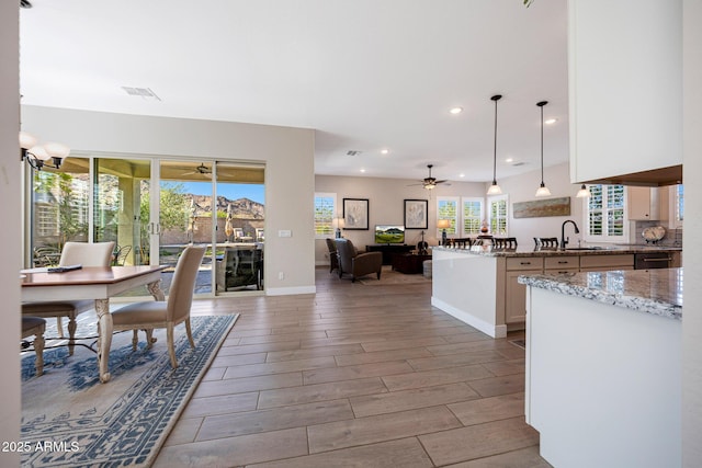21194 W Hillcrest Blvd, Buckeye, AZ 85396 - kitchen featuring a ceiling fan, open floor plan, a sink, light stone counters, and recessed lighting