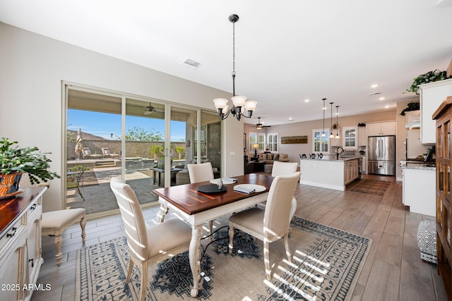 21194 W Hillcrest Blvd, Buckeye, AZ 85396 - dining room featuring a chandelier, healthy amount of natural light, wood finished floors, and recessed lighting