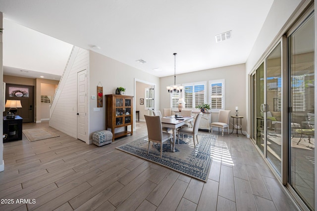 21194 W Hillcrest Blvd, Buckeye, AZ 85396 - dining area featuring light wood-type flooring, a chandelier, stairs, and baseboards