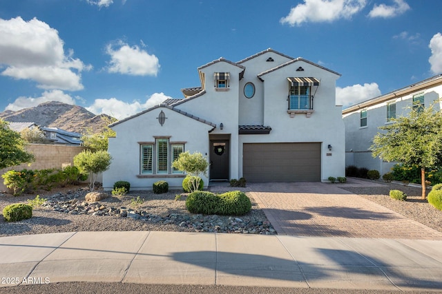 21194 W Hillcrest Blvd, Buckeye, AZ 85396 - mediterranean / spanish home featuring decorative driveway, stucco siding, a garage, and a tiled roof