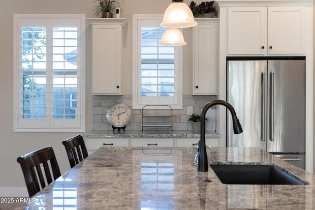 21194 W Hillcrest Blvd, Buckeye, AZ 85396 - kitchen with freestanding refrigerator, healthy amount of natural light, backsplash, and white cabinetry