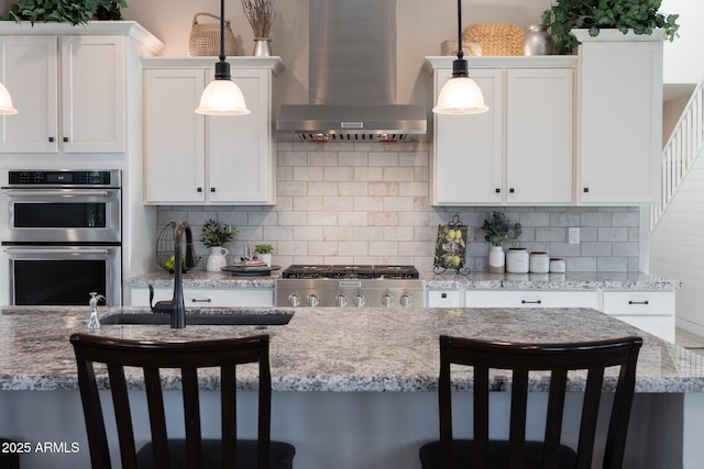 21194 W Hillcrest Blvd, Buckeye, AZ 85396 - kitchen featuring wall chimney exhaust hood, double oven, range, tasteful backsplash, and white cabinets