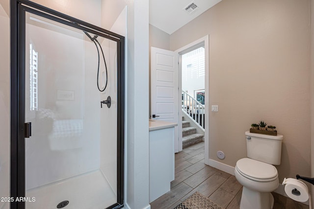 21194 W Hillcrest Blvd, Buckeye, AZ 85396 - bathroom featuring wood tiled floors, a shower stall, toilet, and baseboards